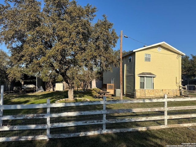 view of home's exterior with central AC unit and a lawn