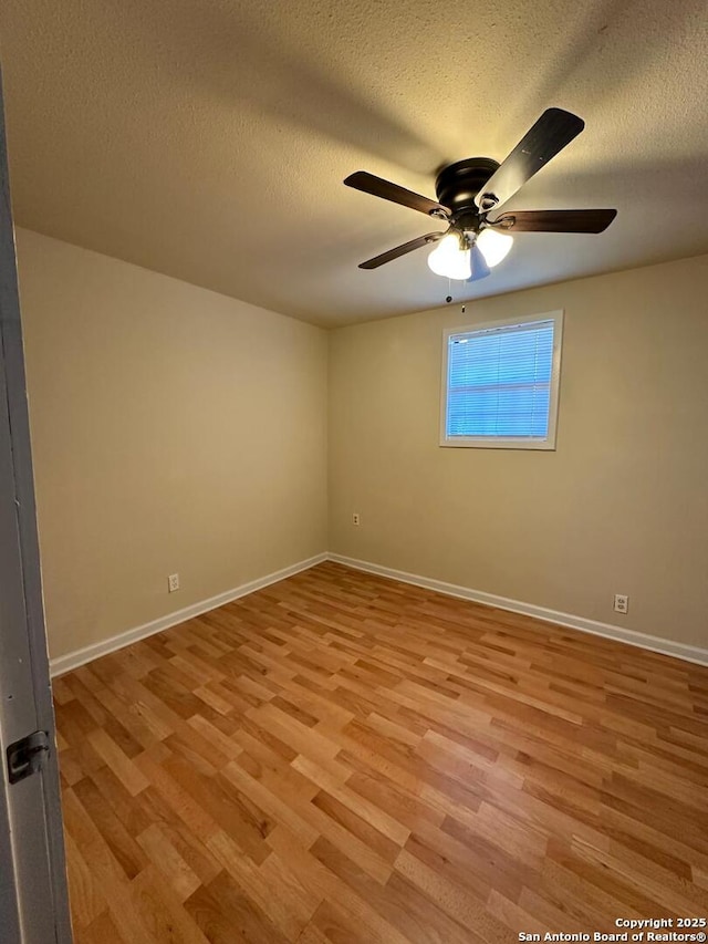 spare room with ceiling fan, light hardwood / wood-style flooring, and a textured ceiling