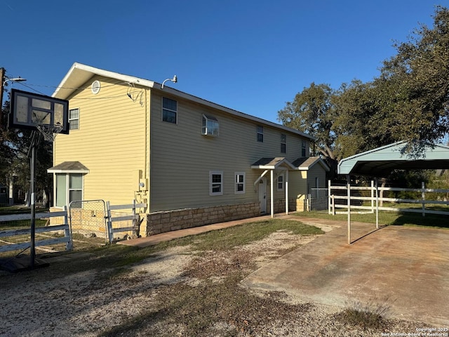 back of house featuring a carport