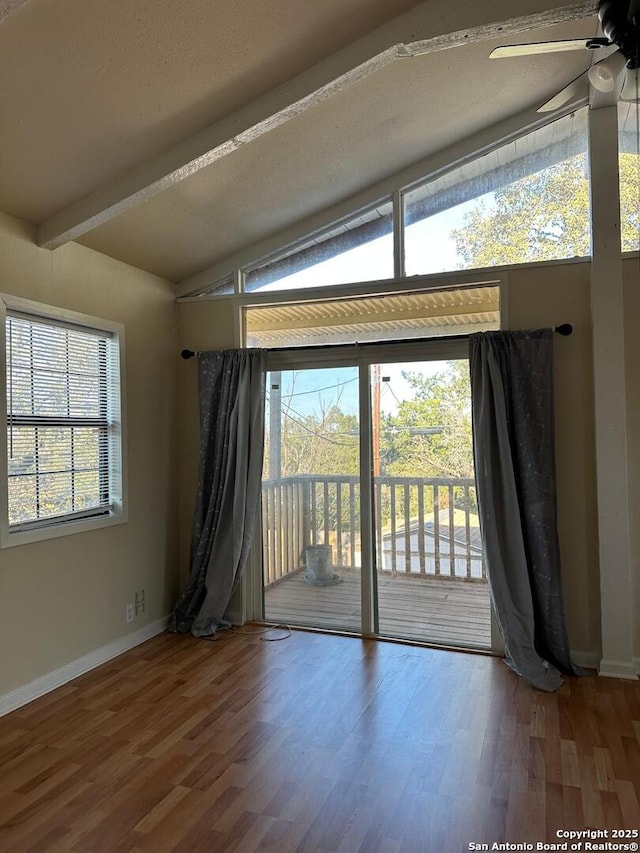 spare room featuring hardwood / wood-style floors, ceiling fan, and lofted ceiling with beams