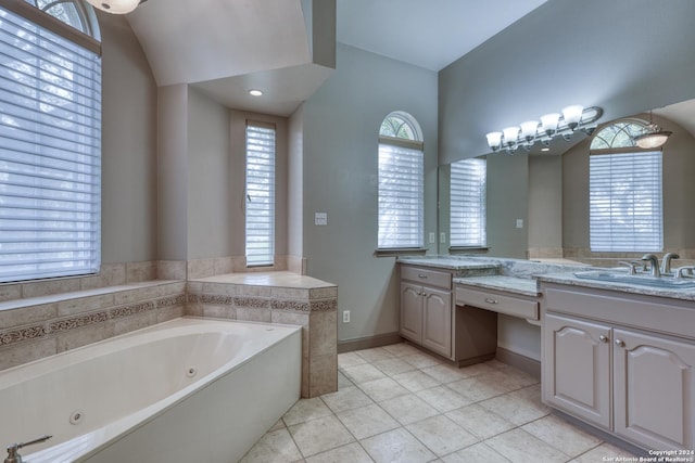 bathroom with tile patterned flooring, vanity, and a tub to relax in