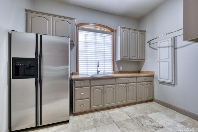 kitchen featuring stainless steel fridge, gray cabinets, and sink