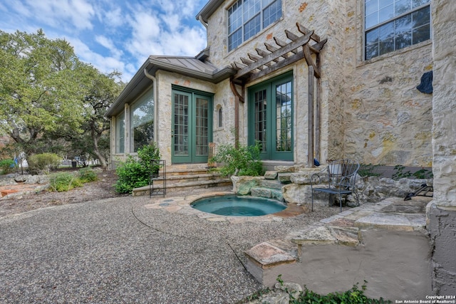 exterior space featuring an in ground hot tub and french doors