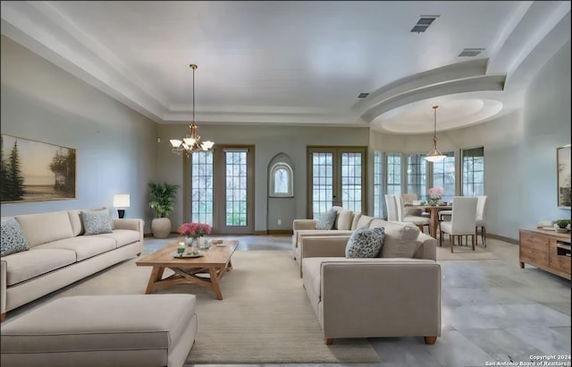 living room with french doors and a notable chandelier