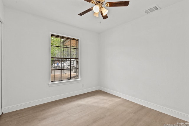 empty room with ceiling fan and light hardwood / wood-style flooring