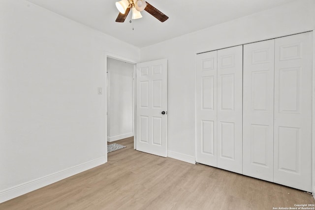 unfurnished bedroom with ceiling fan, a closet, and light wood-type flooring