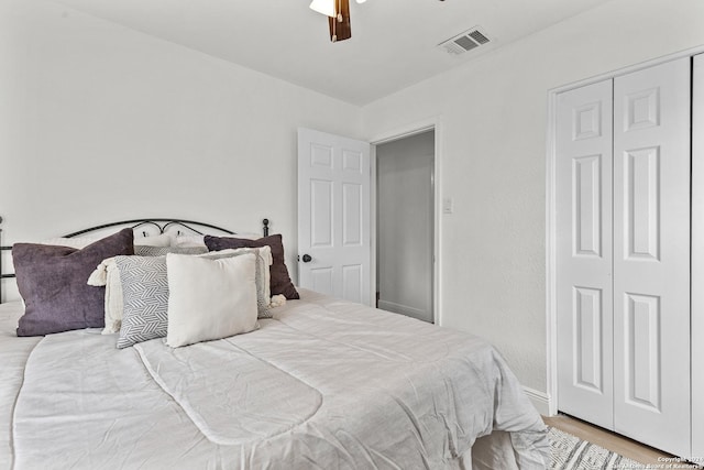 bedroom featuring ceiling fan, a closet, and light hardwood / wood-style flooring