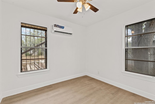 empty room featuring ceiling fan, light wood-type flooring, and an AC wall unit