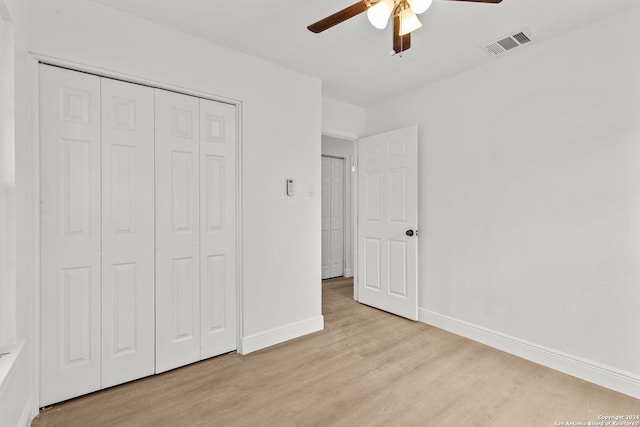 unfurnished bedroom with ceiling fan, a closet, and light wood-type flooring