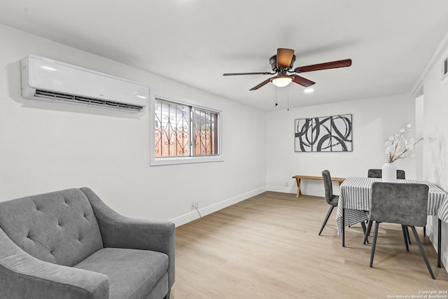 home office featuring ceiling fan, light wood-type flooring, and an AC wall unit