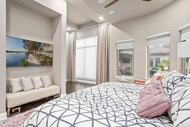 bedroom featuring hardwood / wood-style floors, ceiling fan, and a water view