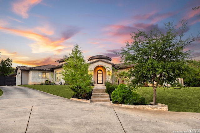 mediterranean / spanish home featuring a lawn and a garage