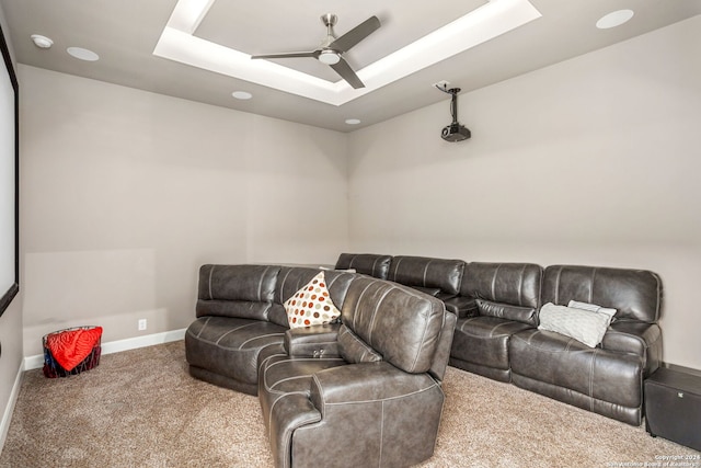 living room featuring carpet floors, a tray ceiling, and ceiling fan