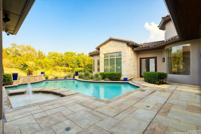 view of pool with pool water feature, a jacuzzi, and french doors