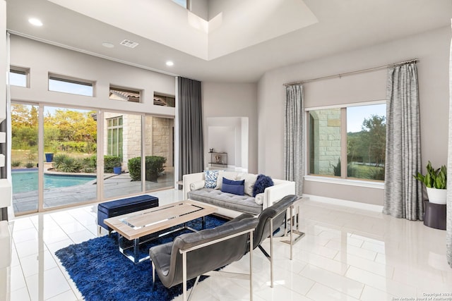 living room with light tile patterned floors and a high ceiling