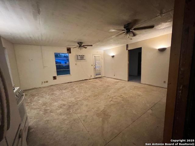 interior space featuring a wall mounted air conditioner and ceiling fan