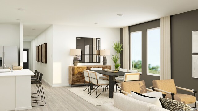 dining space with plenty of natural light, sink, and light hardwood / wood-style flooring