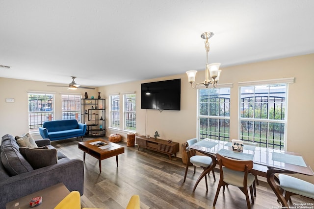 living room featuring ceiling fan with notable chandelier and hardwood / wood-style flooring