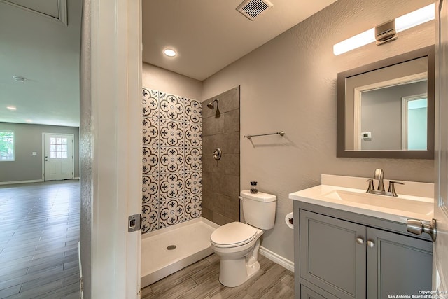 bathroom featuring vanity, toilet, and tiled shower