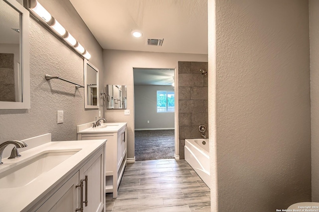 bathroom featuring vanity, wood-type flooring, and tiled shower / bath