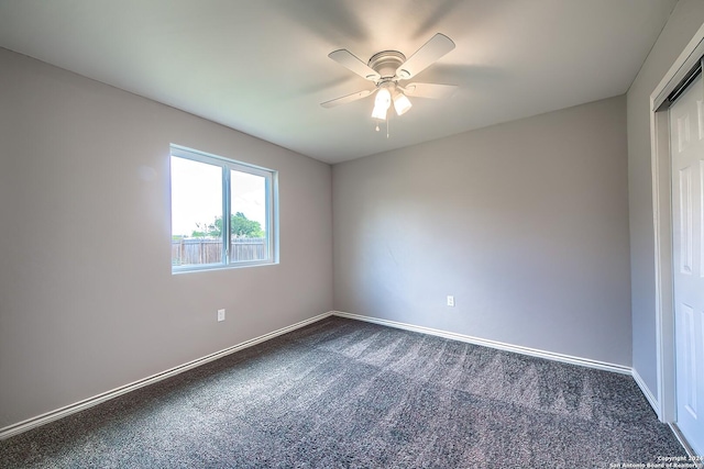 carpeted spare room featuring ceiling fan