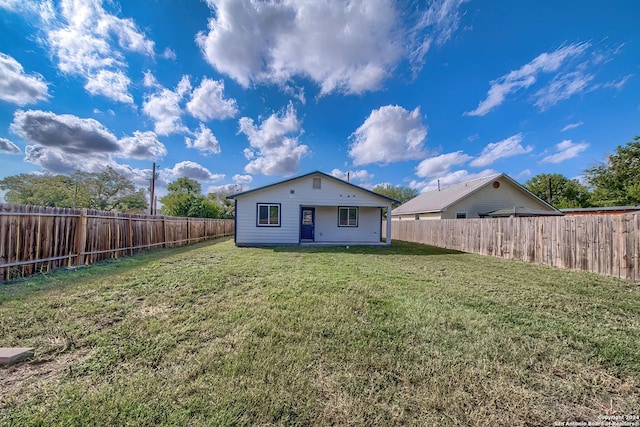 rear view of property featuring a lawn