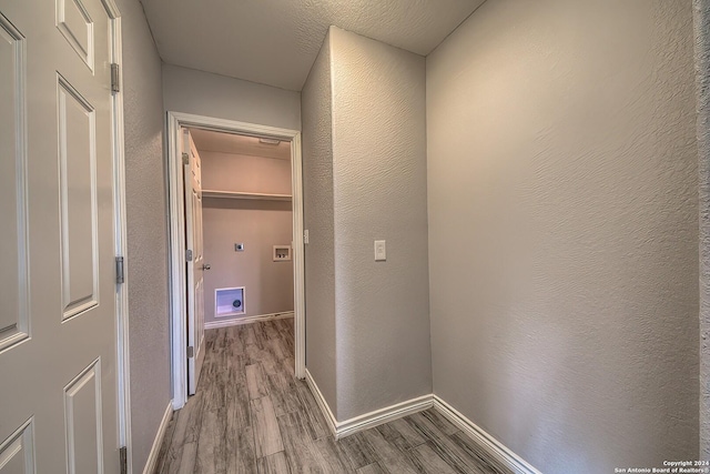 hall featuring light hardwood / wood-style floors and a textured ceiling