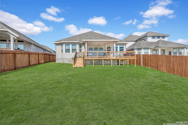 back of property with a lawn and a wooden deck