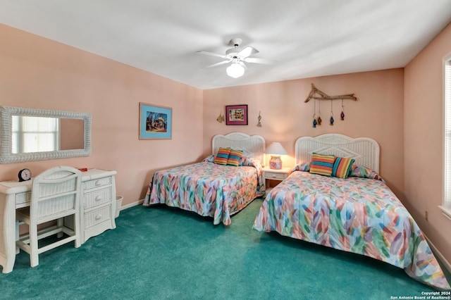 bedroom with ceiling fan, dark carpet, and multiple windows