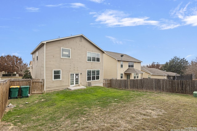 rear view of house featuring french doors and a lawn