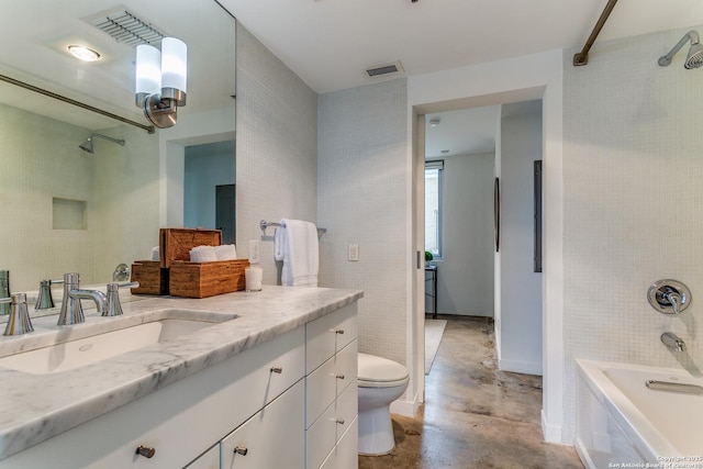 full bathroom with vanity, concrete floors, tiled shower / bath combo, and toilet