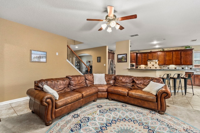 living room featuring light tile patterned floors and ceiling fan