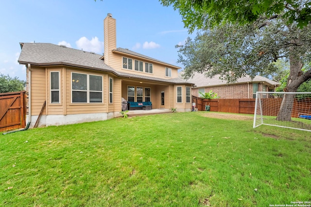 back of house with a patio area and a yard