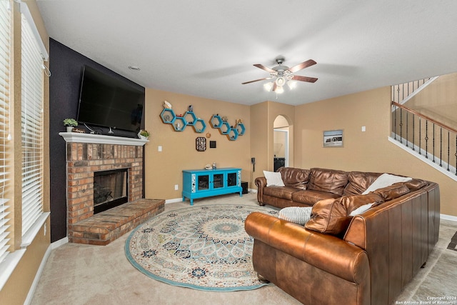 living room with ceiling fan and a brick fireplace