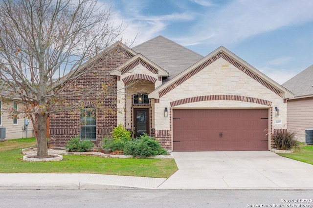 view of front of property with a garage and central AC