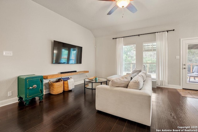 living room featuring dark wood-type flooring, ceiling fan, and vaulted ceiling