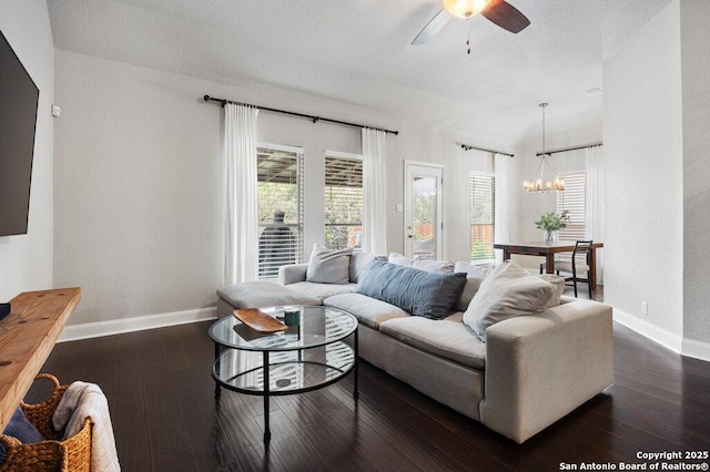 living room featuring ceiling fan with notable chandelier and dark hardwood / wood-style floors