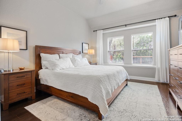 bedroom with lofted ceiling and dark hardwood / wood-style floors