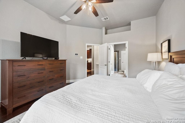 bedroom featuring ceiling fan, ensuite bathroom, and dark hardwood / wood-style floors