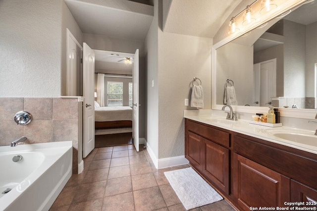 bathroom with tile patterned floors, ceiling fan, a bathtub, and vanity