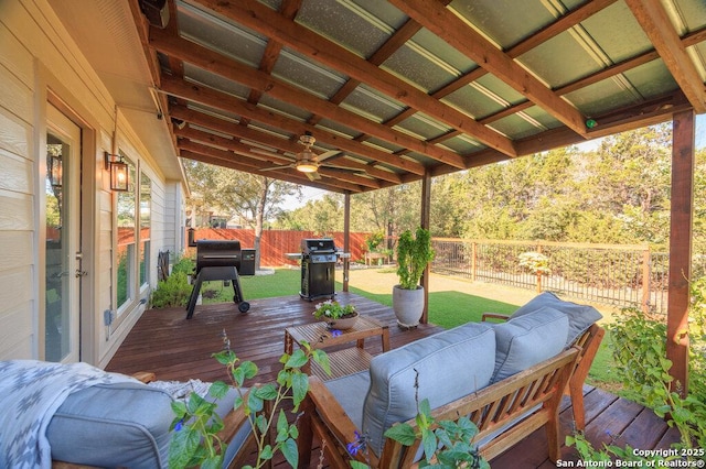 wooden deck featuring an outdoor living space, ceiling fan, a yard, and a grill