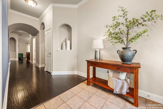 hallway featuring ornamental molding and tile patterned floors