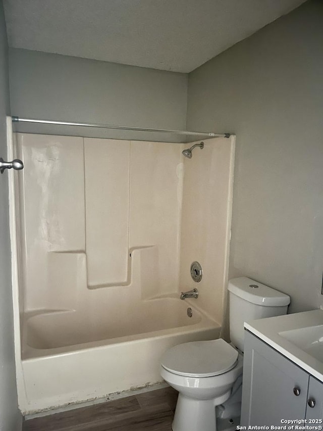 full bathroom with hardwood / wood-style flooring, shower / bath combination, vanity, a textured ceiling, and toilet