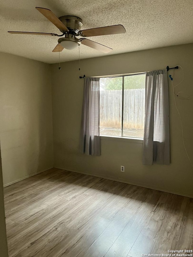 spare room featuring ceiling fan, a textured ceiling, and light wood-type flooring