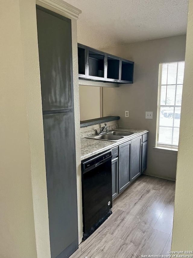 kitchen with sink, a textured ceiling, dishwasher, and light wood-type flooring