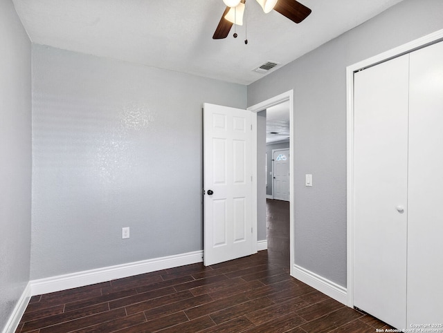 unfurnished bedroom with ceiling fan and a closet