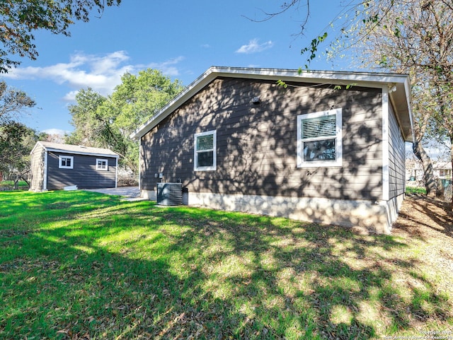 back of house with central AC and a lawn