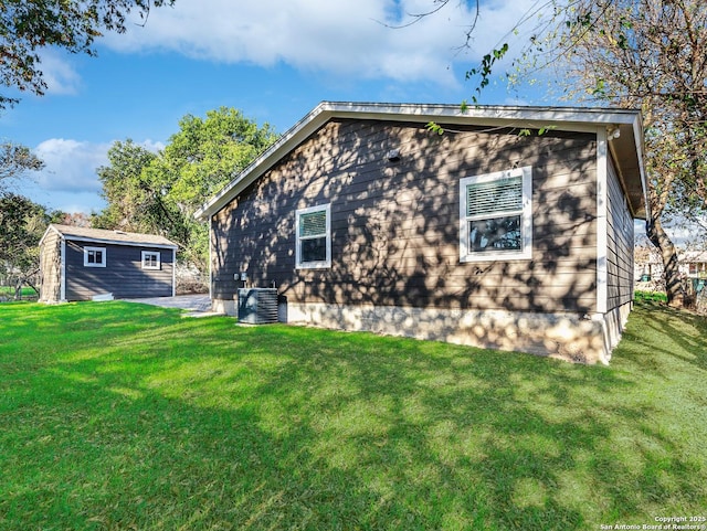 back of house featuring an outbuilding and a yard