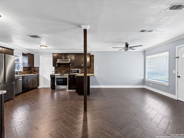 kitchen featuring sink, decorative backsplash, ceiling fan, appliances with stainless steel finishes, and dark brown cabinets