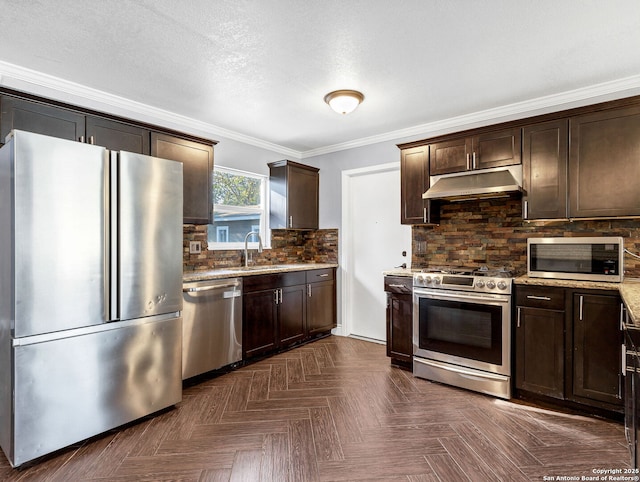 kitchen featuring dark brown cabinets, light stone counters, appliances with stainless steel finishes, and tasteful backsplash